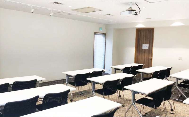 プロジェクター投影可能な壁面にテーブルと椅子をスクール形式で並べたレイアウトです。